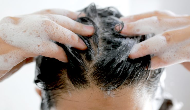 Donna con shampoo nei capelli