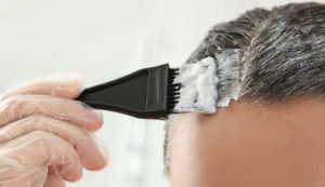 Donna applica la tinta per capelli